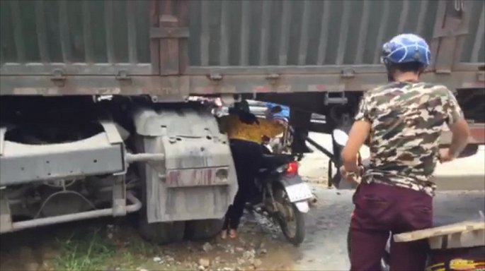 Container chan ngang quoc lo, dan dat xe may chui qua gam hinh anh 1